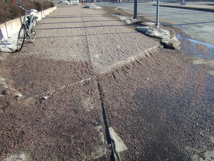 Tältä näyttävät pyörätiet pitkään lumien sulamisen jälkeen. Sepelin alla on asfalttipintainen pyörätie.